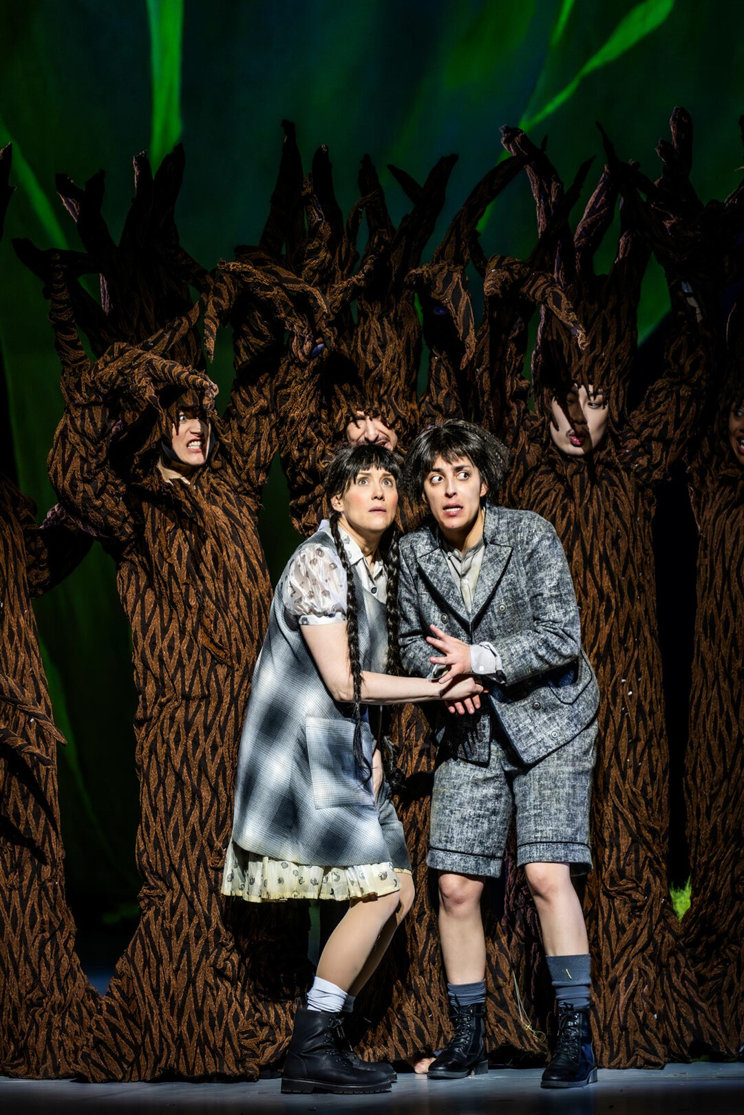 Gretel und Hänsel stehen vor Tänzer:innen im Baumkostümen