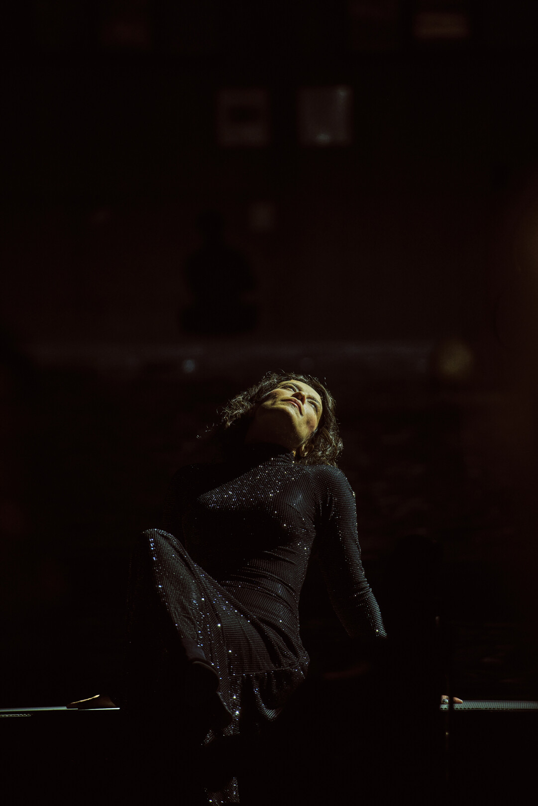 Sopranisitin Gloria Rehm in schwarzem Kleid liegt am Bühnenrand, Szene aus 